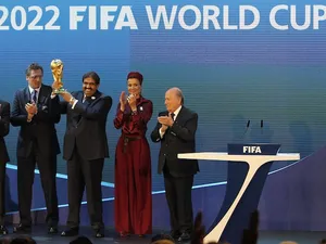 Qatar's Emir Sheikh Hamad bin Khalifa al-Thani (C) raises the World Cup trophy as he stands with FIFA president Sepp Blatter (R) after Qatar was chosen to host the 2022 World Cup at the FIFA headquarters in Zurich on December 2, 2010