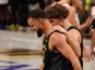 Golden State Warriors' Stephen Curry walks slowly upcourt with Brandin Podziemski