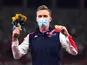 Gold medallist Karsten Warholm of Norway celebrates on the podium as he wears a face mask on August 3, 2021