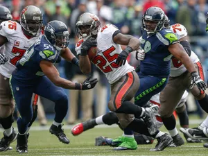 Running back Mike James #25 of the Tampa Bay Buccaneers rushes against middle linebacker Bobby Wagner #54 of the Seattle Seahawks at CenturyLink Field on November 3, 2013