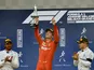 Charles Leclerc celebrates with a trophy on the podium after winning the race as he applauded by second placed Mercedes' Lewis Hamilton and third placed Mercedes' Valtteri Bottas on September 1, 2019