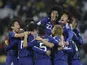 Japan's players celebrate after reaching the knockout stages of the 2014 World Cup