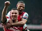 Lukas Podolski is congratulated by Kieran Gibbs after scoring his team's second goal against Norwich on April 13, 2013