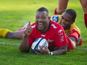 Toulon's flanker Steffon Armitage celebrates after scoring a try despite a tackle by Llanelli Scarlets' wing Michael Tagicakibau during the European Rugby Champions Cup match between Toulon and Llanelli Scarlets at the Mayol stadium in Toulon, southeaster